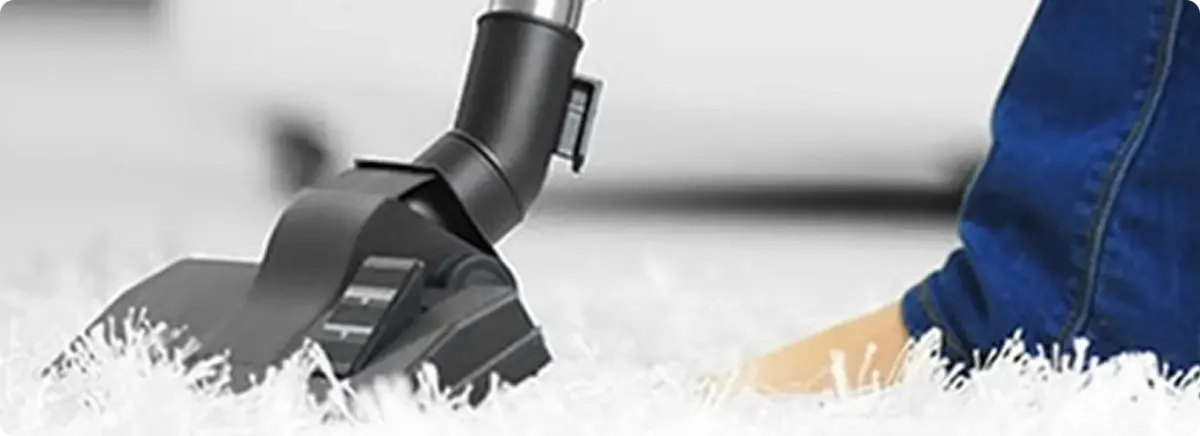 Close-up of a professional vacuuming a white carpet in Tempe.